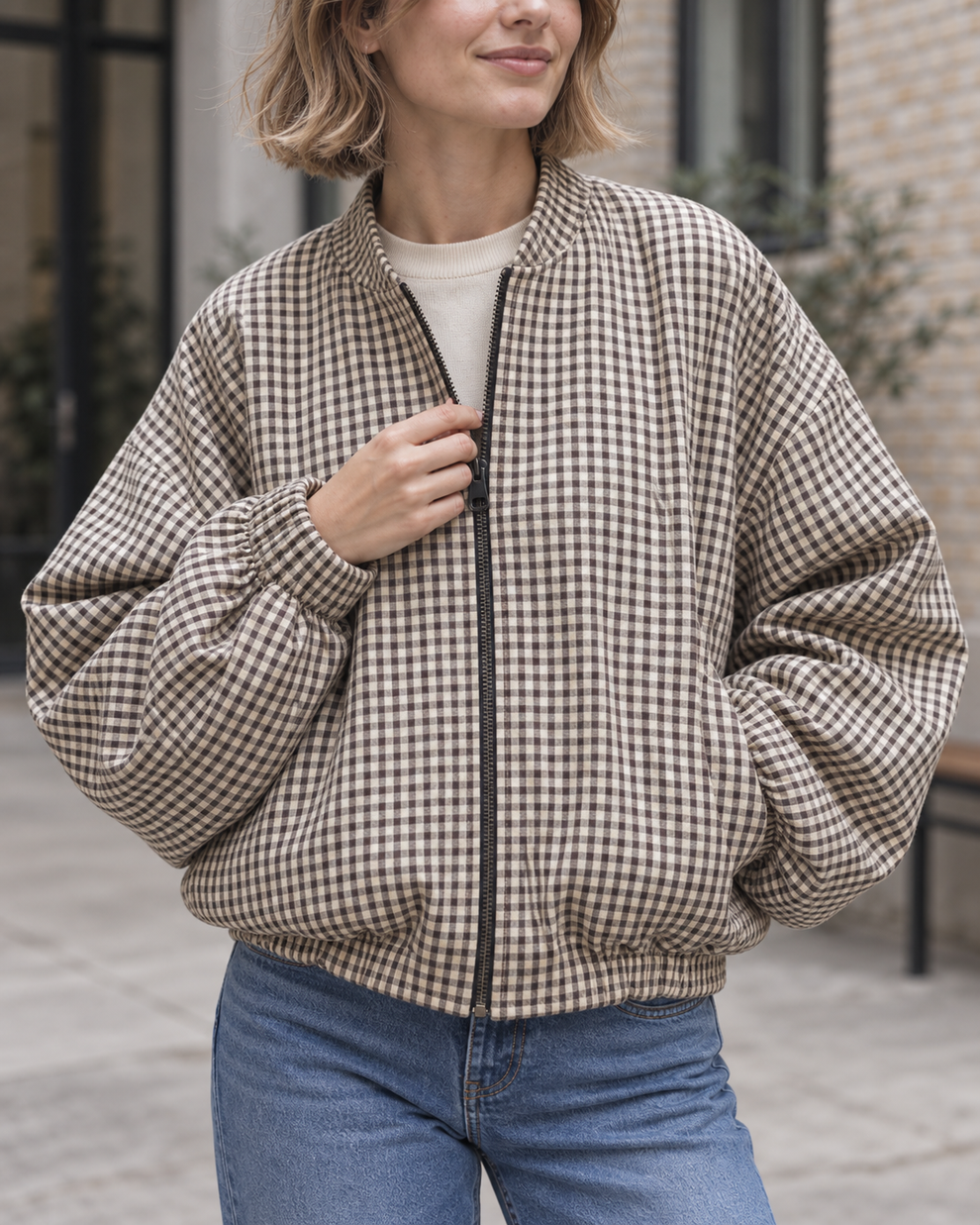 Close view of the bomber check, zipper and gathered hem